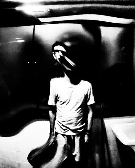 a black and picture of me, distorted by glass between the camera and myself.